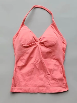 Rosa halterneck linnetopp - Snygg rosa linnetopp med halterneck och lätt rynkdetalj framtill. Toppen är ärmlös och har en feminin v-ringning. Passar som XS-S🥰