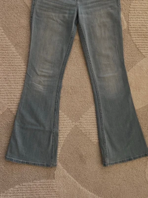 Ljusblå bootcut jeans Hollister - Säljer ett par ljusblå bootcut jeans från Hollister med klassisk femficksdesign och låg midja. Jeansen har en snygg tvättad look och vida ben som ger en retrovibe. Perfekta för dig som gillar avslappnad stil och vill sticka ut lite extra.