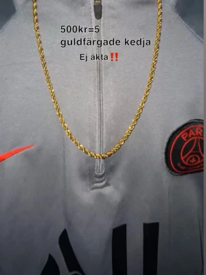 Guldfärgat kedjehalsband - Snyggt guldfärgat halsband med tvinnad kedja. Perfekt accessoar för att lyfta din outfit med en trendig touch. Halsbandet är inte äkta guld utan har en guldfärgad finish som ger en cool look.