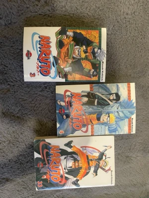 Naruto manga volym 3, 4 och 33 - Tre Naruto-mangaböcker av Masashi Kishimoto, volym 3, 4 och 33. Omslagen är färgglada med karaktärer som Naruto, Kakashi och Sasuke. Perfekt för dig som gillar actionfylld shonen-manga och vill bygga på din samling.