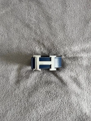 Blått H-bälte 105cm - Snyggt blått skärp med klassiskt H-format spänne i silverfärg. Skärpet är gjort i skinn och har en stilren, minimalistisk design som passar till många olika outfits. Pris kan diskuteras 