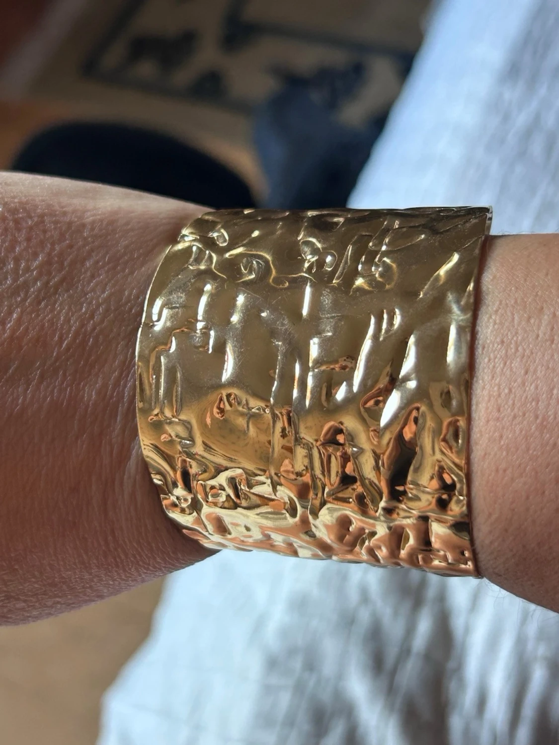 Brett guldigt armband med hamrad yta