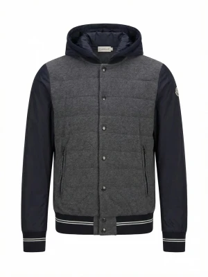 Moncler grå och marinblå bomberjacka - Snygg bomberjacka från Moncler i grått och marinblått. Jackan har quiltad framsida, släta ärmar, huva och ribbade muddar med vita ränder. Två dragkedjefickor och Moncler-logga på ärmen. Perfekt för dig som vill ha en stilren och sportig look.