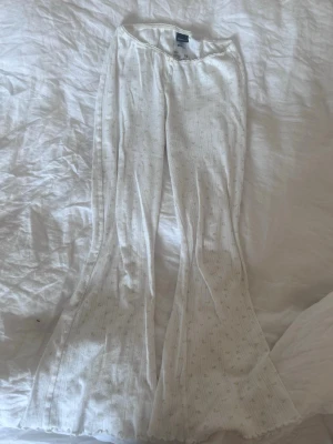 Vita ribbade mjukisbyxor Gina Tricot - Säljer ett par vita mjukisbyxor från Gina Tricot i ribbat material. Byxorna har utsvängda ben och en mjuk resår i midjan. De har diskreta små prickar i mönstret och är perfekta för en chill och avslappnad stil. Jag har använt byxorna 3 gånger då jag känt att dom inte riktigt va min stil💕 pris kan diskuteras