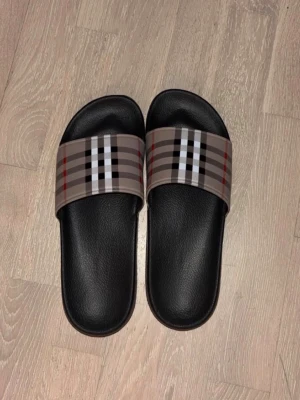 Burberry tofflor  - Hej, säljer dessa burburry tofflor då de är lite små på mig. Fraktar runt hela Sverige eller möts upp i Sthlm. 