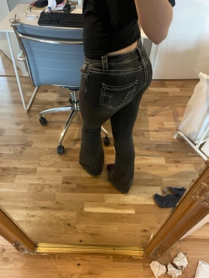 Svarta bootcut jeans med kontrastsömmar - Säljer ett par mörkgrå bootcut jeans med vita kontrastsömmar!💞Jeansen är lågmidjade och bootcut från Gina Tricot. Endast använda fåtal gånger💕är i storlek S. 