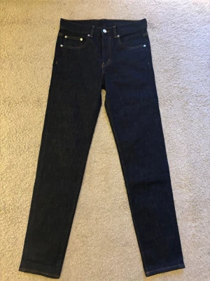 Mörkblå slim fit byxor från Arket - Snygga mörkblå jeans från Arket i klassisk femficksmodell med slim fit passform och Jeansen har kontrastsömmar. Helt nya och aldrig änvenda. Ny pris 900 kr (pris kan diskuteras)