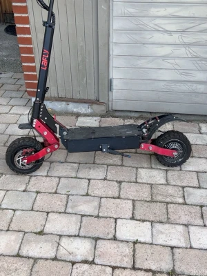 Elsparkcykel LaFly svart/röd - Säljer en kraftfull elscooter från LaFly i svart och rött. Scootern har grova däck för bättre grepp, robust ram i metall och bred fotplatta. Perfekt för dig som vill ta dig fram snabbt och smidigt i stan eller på grusvägar. DUBBLA MOTORER & laddningsuttag för dubbelt så snabb laddning. TOPPFART 80km/h. 90km räkvidd 