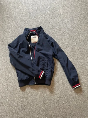 Marinblå vindjacka Tommy hilfiger - Säljer min snygga Tommy hilfiger jacka till bra pris | hör av dig vid funderingar 