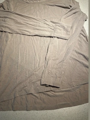 Beige långärmad topp från Cubus - En enkel och mjuk beige långärmad tröj afrån Cubus. Tröjan har rund halsringning och är tillverkad i ett tunt, stretchigt material som känns skönt mot huden. Perfekt att styla lager på lager eller bära som den är. pyjamströja 