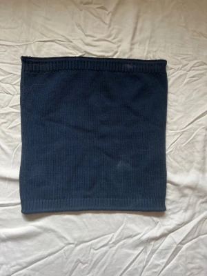 Marinblå stickad tubkjol Gina Tricot - Säljer en mörkblå stickad tubtopp från Gina Tricot i storlek M. Toppen är ribbad upptill och nedtill för en snygg passform och har en enkel, stilren design som är lätt att matcha med olika outfits. 2 fläckar framtill men går troligen bort i tvätten! Tvättar innan jag postar!