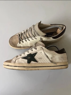Golden Goose  - Halloj. Jag säljer nu mina riktigt feta goolden goose som jag haft i runt ett halvår. Dom är köpta ifrån merch Sweden för 4500kr. Dom är i rätt så gott skick men de finns några slitningar och som ni ser på 3 bilden så är sulan trasig men provisionallt limmad. Hör gjärna av er☺️