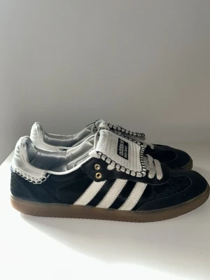 Adidas x Wales Bonner Sambas Skor - Välanvända Wales Bonner Sambas i svart. Eftertraktad collab med premiumdetaljer och unik design. Skicket är som på bilderna. Kan va lite smutsiga samt ha jeans fläckar, men det kan enkelt tvättas bort. Samt kan det saknas mocka på vissa små ställen men det märks inte särskilt mycket. Skick: 7/10 Pris kan diskuteras 📦 Skickas eller möts upp