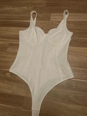 Vit body - Super fin men lite för stor på mig, därav säljer jag den💞har ett litet ”blommigt” mönster (se sista bild) inga defekter💞