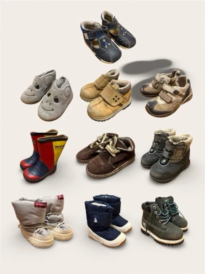 Stort Skopaket Småbarn (10 par) – Kavat, Pop, Timberland – Strl 21-22 - Säljer ett rejält paket med 10 par barnskor för alla säsonger. Perfekt för dig som vill fylla upp garderoben med kvalitetsskor i ett svep. Säljes som ett komplett paket.  Paketet innehåller:  Kavat: Grå vinterskor (Strl 22).  Polarn O. Pyret (Pop): Blå vinterskor (Strl 22).  Timberland: Mörkgröna skor (Strl 5M/bebis).  Kavat: Blå tofflor (Strl 22).  Vincent: Grå tofflor med smiley (Strl 21).  En Voitures!: Antis-skor (Strl 22).  Fit Gore-Tex: Funktionsskor (Ca strl 22).  Wetwork: Gummistövlar (S