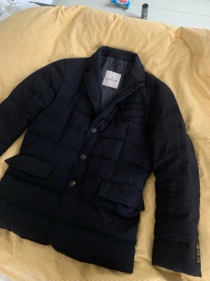 Mörkblå dunjacka blazer från Moncler - Stilren svart dunjacka från Moncler med klassisk kavajkrage och knäppning framtill. Jackan har två stora fickor med lock och en bröstficka. Quiltad design och diskreta knappar ger en clean look. Perfekt för dig som vill ha både värme och stil. Nypris över 10000. Storlek 1 motsvarar S möjligtvis mot XS hållet