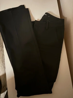 Svarta kostymbyxor från Selected - Snygga svarta mid waist kostymbyxor från Bikbok i storlek 34.