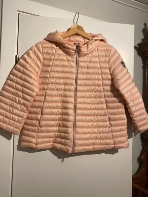 Ljusrosa dunjacka med huva från Colmar - vårjacka!  - Snygg ljusrosa dunjacka med trekvartsärmar och huva. Jackan är endast provad och aldrig använd så den är helt i nyskick! Superfin! Väldigt lättviktig jacka! 