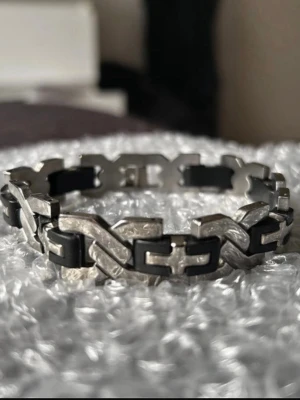 Armband i rostfritt stål   - Snyggt armband med kedjedesign i stainless steel och svarta detaljer. Justerbar i storlek