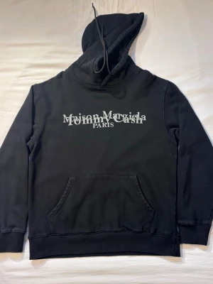 Maison Margiela svart hoodie  - Jag säljer en svart maiden margiela hoodie med reflex tryck. Tröjan passar dig som är ca 170-185 beroende på hur du vill att den ska sitta. Tröjan är köpt av min bror för ca 2 månader sedan. Hör av er vid minsta lilla fråga eller prisförslag✌️