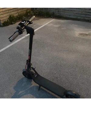 Svart elscooter med LED-ljus - Säljer en svart elscooter med robust ram och LED-ljus framtill. Scootern har bred fotplatta, handtag med bra grepp och röda detaljer vid hjulen. Perfekt för smidig transport i stan. för mer information skriv till mig!