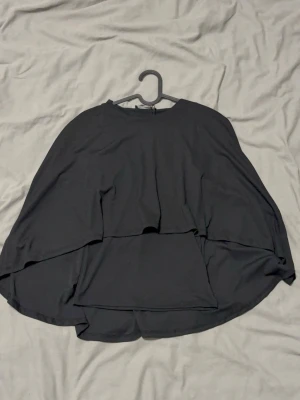 Cape top från Gina Tricot - Jätte snygg top med en insydd flowig cape, sitter som en smek, perfekt för dig som gillar att testa nya unika klädesplagg!