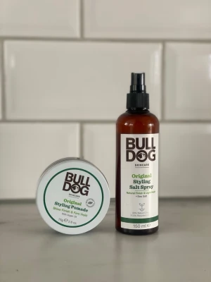 Bulldog Styling Pomada & Salt Spray - Säljer ett set med Bulldog Original Styling Pomade och Original Styling Salt Spray. Pomadan ger glans och stadga, medan salt sprayen ger naturlig finish och lätt stadga. Båda produkterna är i bruna och vita förpackningar och passar perfekt för hårstyling.
