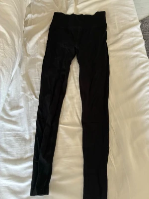 Svarta tränings tights från NA - Säljer ett par svarta leggings från NA i storlek 170. De är tillverkade i en mjuk och stretchig blandning av nylon och elastan, med bred resår i midjan för extra komfort. 