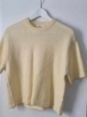 Gul kortärmad stickad tröja Gina Tricot  - Mysig ljusgul stickad tröja från Gina Tricot med korta ärmar och rund halsringning. 