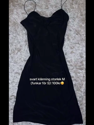 Svart axelbandsklänning - En enkel och stilren svart klänning med tunna axelband och figurnära passform. Klänningen har en kort längd och är perfekt för dig som gillar minimalistisk stil. Passar både till vardags och när du vill klä upp dig lite extra.