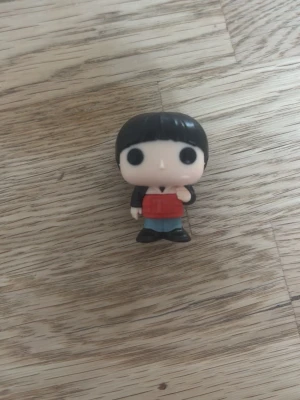 Funko Pop figur will i stranger things  - Säljer en Funko Pop vinylfigur med svart hår, stora svarta ögon och en röd tröja. Figuren har blå byxor och svarta skor. Från kinder joy. Will byers från stranger things. Perfekt för dig som samlar på Pop-figurer eller vill ha en cool dekoration till rummet. 