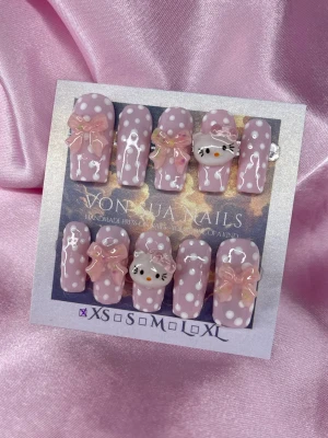 BabyKitty (XS);Medium Square; Curved - Supergulliga handgjirda press-on naglar i ljusrosa med vita prickar handgjorda av mig. Dekorerade med 3D-rosetter och Hello Kitty-detaljer. Naglarna har en blank finish och en söt, lek mon design som verkligen sticker ut. Perfekta för dig som vill ha något unikt och kreativt.XS: 14 mm, 11 mm, 11,5 mm, 10 mm, 8 mm 