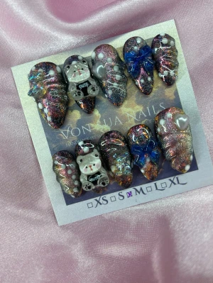 DarkSugar (M);Medium Almond - Unika handgjorda press-on naglar i en medium mandelform med svart, rosa och holografiskt glitter. Dekorerade med 3D-nallebjörnar, blå rosetter, vita hjärtan och pärlor. Perfekt för dig som vill ha något extra och kreativt på naglarna.M: 16 mm, 12 mm, 12,5 mm, 11,5 mm, 10 mm