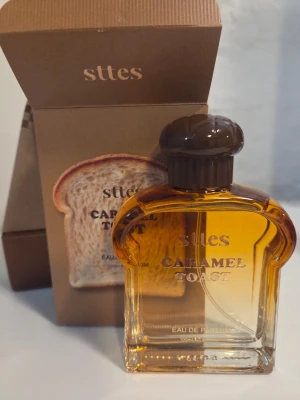 Sttes Caramel Toast Eau de Parfum - Använd några gånger, innehåll se bild. Unik parfym med söt och gourmand doftprofil från Sttes. Flaskan är formad som en brödskiva i brunt glas och rymmer 100 ml. Doften har toppnoter av choklad, kaffe och ananas, hjärtnoter av vanilj, mjölk, godis, äpple och päron samt basnoter av vanilj och kola.