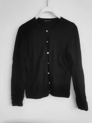 Kofta med silverfärgade knappar - Lite nopprig på sidorna (vid höften), men annars i gott skick. 