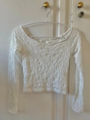 Vit långärmad croppad topp H&M - Säljer en vit långärmad croppad topp från H&M. Den är gjord i spets men har dubbellager fram och bak 🫶🏻