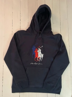 Ralph Lauren hoodie herr, storlek L  - Hej! Säljer denna riktigt schyssta hoodie från Ralph Lauren. Den är i storlek XL men sitter en storlek litet och passar därför som en L. Den är endast använd någon enstaka gång och är därmed i ett nyskick. Original lappar och påse finns kvar och medföljer naturligtvis vid köp. Jag fraktar alltid snabbt! Mvh