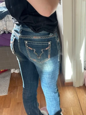 jeans med detalj  - Supercoola jeans jag köpte i usa i en butik pp route 66! Nypris ca 900kr, har ett litet hål se bild 6 samt lite slitage vid hälarna( bild 7) men inget ma. lägger märke till.  size 25, amerikansk strl. Midjemått 37 rakt över. 