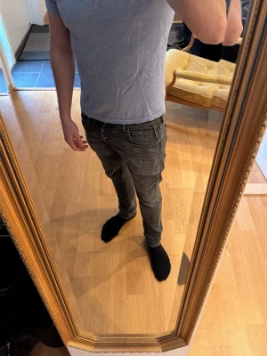 Grå slim fit jeans - En enkel och stilren ljusblå piké med rund hals och korta ärmar. T-shirten har en slim fit passform och är tillverkad i ett mjukt och stretchigt material som sitter skönt mot kroppen. Perfekt att matcha med jeans eller shorts. Tröjan är från John Henric och är välvårdad.