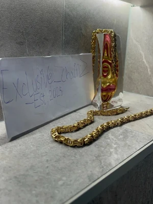 Tung guldlänk halsband - Säljer ett riktigt fett halsband med tjock guldlänk i glänsande metall. Länkarna har en unik, nästan fyrkantig form som ger ett exklusivt intryck. Perfekt för dig som vill sticka ut och addera lite extra bling till din stil. Märke: Exclusive Chainz.