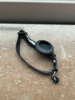 Katthalsband med gps hållare  - Ett svart säkerhetshalsband med gps hållare till katt, och en blingra. Aldrig använd. 