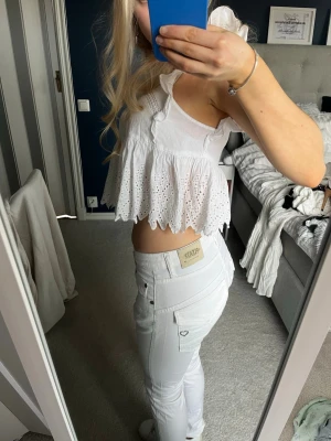 Vita raka Lågmidjade jeans  - Säljer ett par vita jeans från please med rak passform och låg midja. Jeansen har klassiska fickor både fram och bak samt bälteshällor. Materialet är stretchigt och bekvämt, perfekt för en clean och fräsch look.