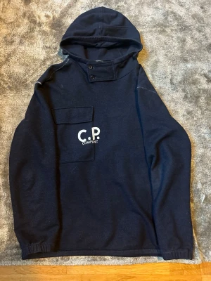 Mörkblå hoodie från C.P. Company - Snygg marinblå hoodie från C.P. Company. Använd Max 10 gånger den är som ny. Den är väldigt sällsynt. Har kvitto. Nypris ligger på 4000🤑