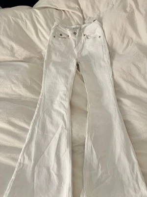 Vita lågmidjade bootcut jeans från stradivarius - Säljer ett par vita bootcut jeans från stradivarius storlek 34.