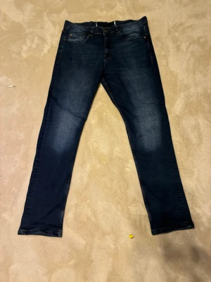 Mörkblå skinny jeans med slitningar - Snygga mörkblå skinny jeans med lätt slitna detaljer på framsidan och baksidan. Klassisk femficksmodell med knapp- och dragkedjegylf. Jeansen har en smal passform och är perfekta för en trendig och avslappnad look priset kan diskuteras vid snabb afär⚠️