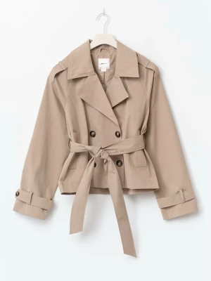 Trendig trenchcoat från Gina - Stilren kort trenchcoat från Gina Young 14+. Jackan har en fin beige färg, dubbelknäppning, breda slag och en snygg knytning i midjan. Jackan har bruna knappar på ärmsluten och två sidofickor. Jackan är helt i nytt skick! Använt 1-2 gånger. Det är en tunn och skön kappa. Perfekt inför våren! Och soliga dagar☀️VIKTIGT: lägsta pris är 400