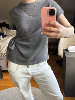 Topp med knyt - Snygg grå topp med korta ärmar och ett unikt knyt i sidan som ger en cool twist💗 Priset är diskuterbart vid snabb affär🥰