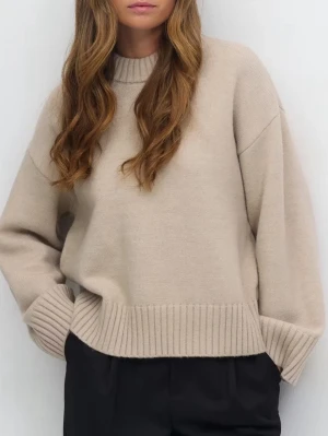 Beige oversized stickad tröja - Säljer en beige oversized stickad tröja med bred ribbstickad kant vid ärmslut och nederkant. Tröjan har rund halsringning och långa ärmar. Perfekt för dig som gillar en avslappnad och trendig look.
