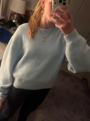 Turkos tröja från other stories - Mysig turkos stickad tröja med en bra passform och långa ärmar. Tröjan har ribbade muddar vid ärmslut och nederkant. Perfekt för lager på lager och en avslappnad stil.