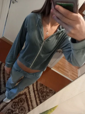 Grå velour hoodie med dragkedja - Snygg grön/grå velour hoodie med dragkedja framtill och justerbar huva med snören. Croppad modell som ger en avslappnad och trendig look. Perfekt till jeans eller mjukisbyxor för en chill stil. Från gina tricot 158-164.Använd bara några gånger.